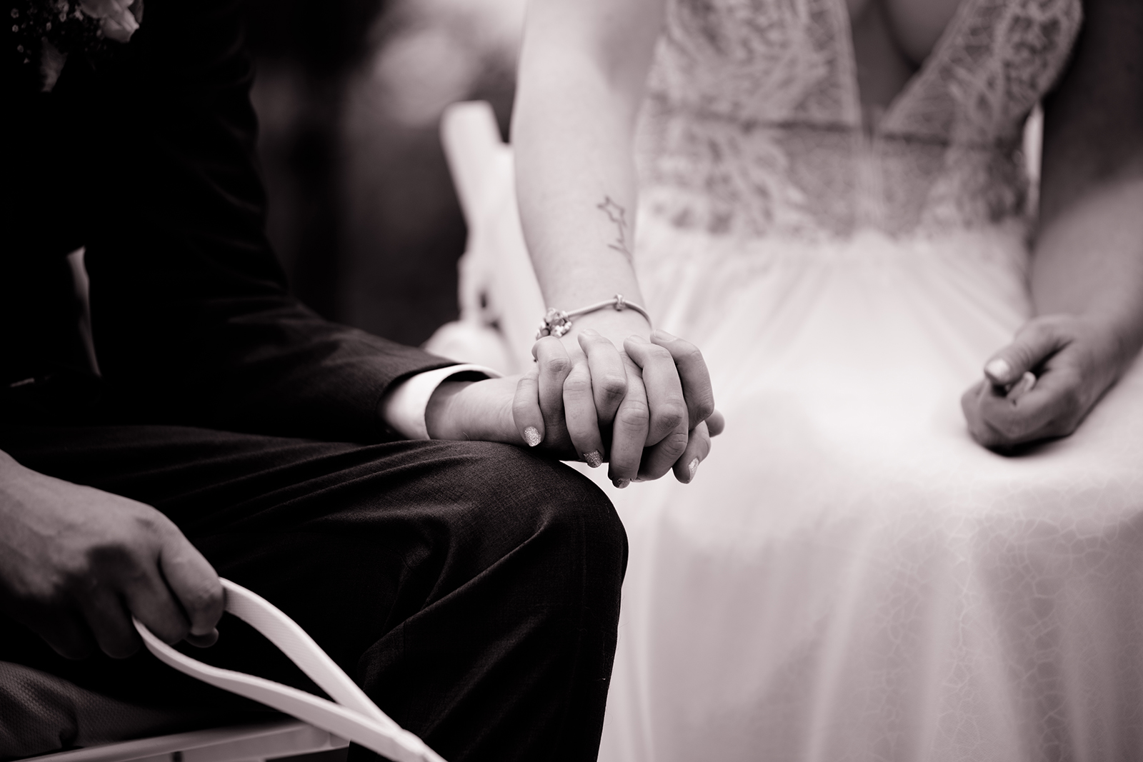 Händchenhalten während der Trauung in schwarz-weiß