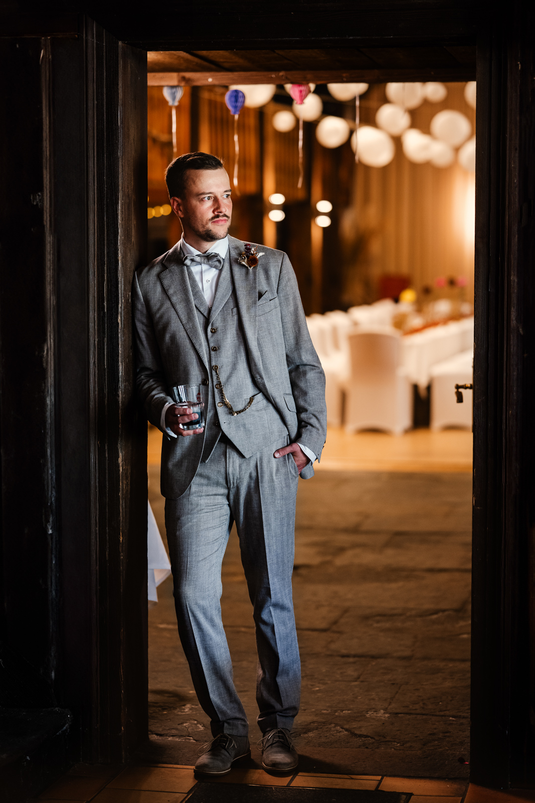 Bräutigam in Türrahmen mit Festsaal im Hintergrund