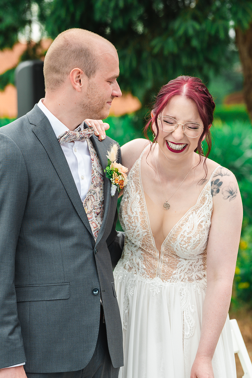 Braut und Bräutigam lachen bei der Rede des Trauredners bei einer Freien Trauung in Rinteln