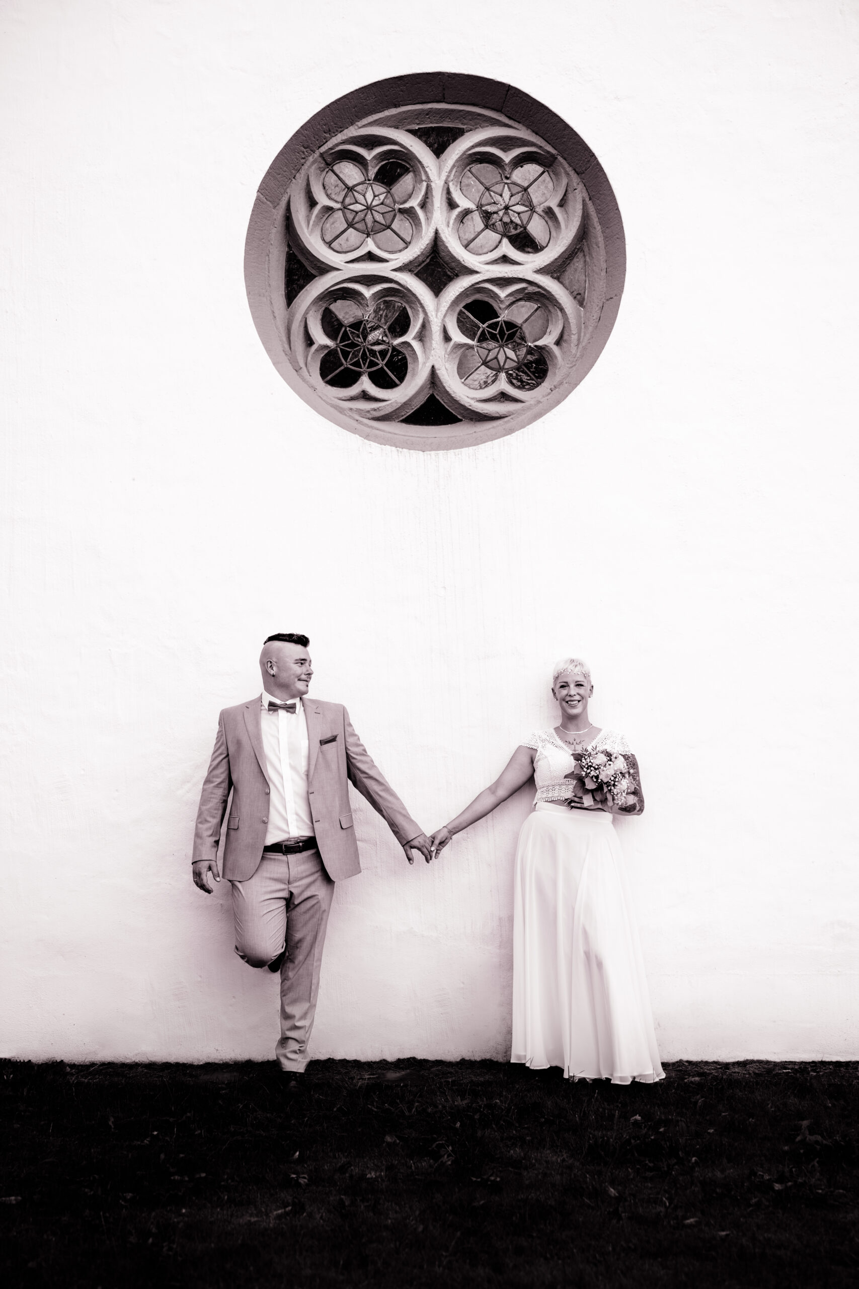 Brautpaar vor Kirchenfenster im Kalletal