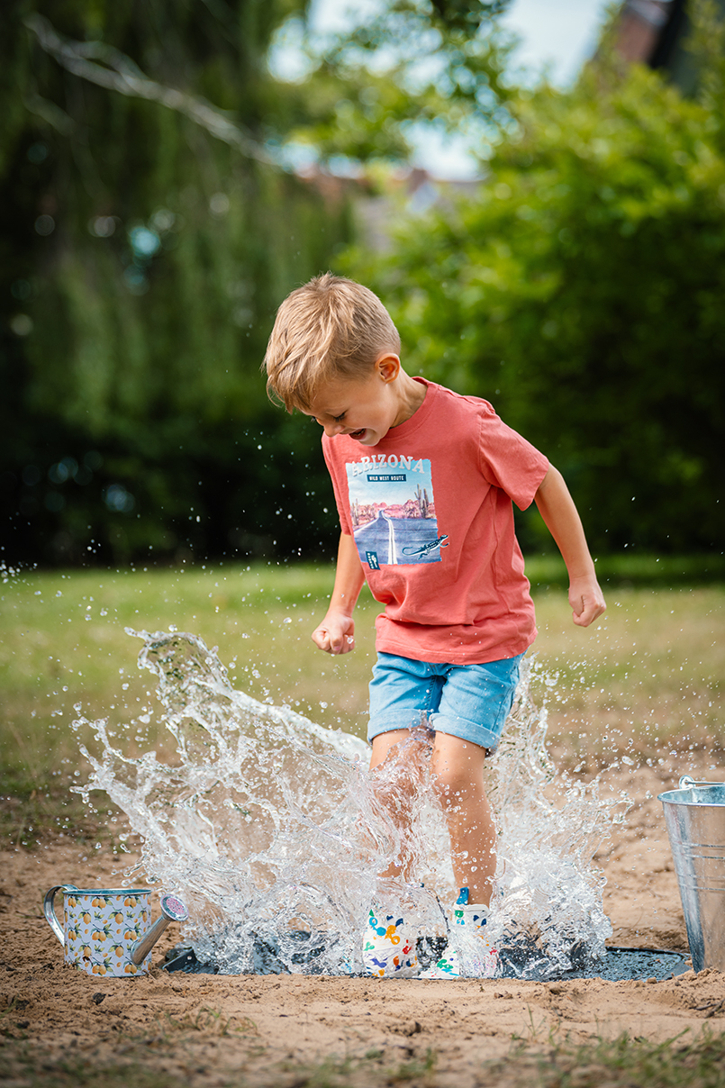 Q5GS6BNVQ (1) Kind springt in Fütze im Kindergarten Eisbergen