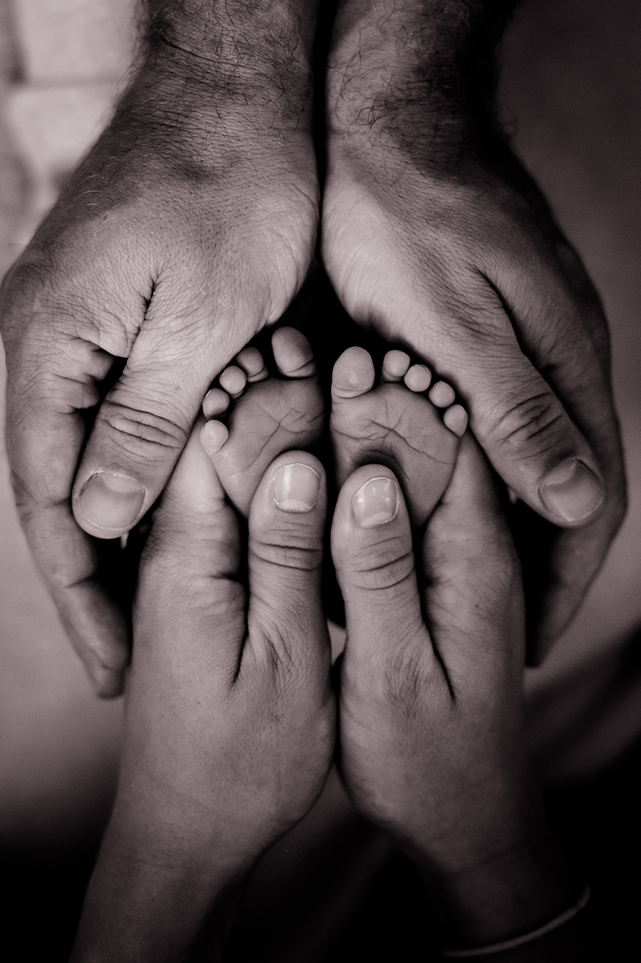 Pepe (1) Babyfüße gehalten von den Händen der Eltern